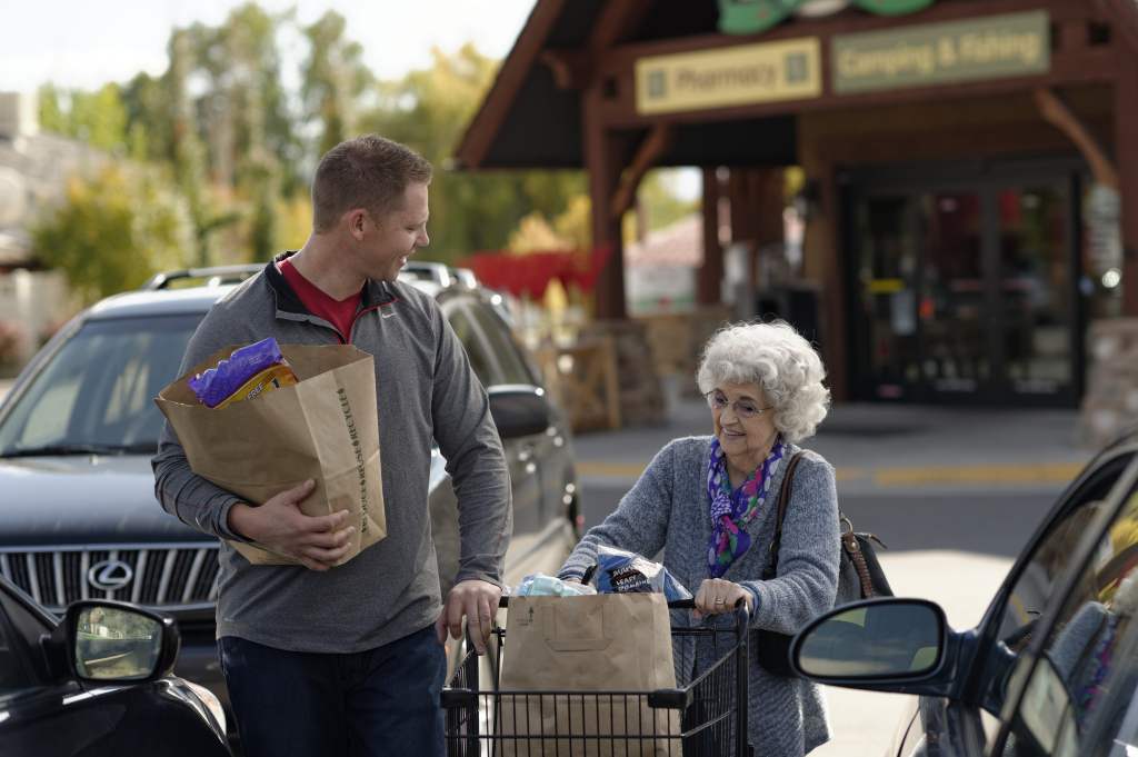 man helping elderly woman groceries